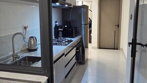 A modern kitchen with a stainless steel sink, a coffee maker, and a stove. - Brand New Westlands 1BR 1Ba Walk to Sarit GTC (Nairobi)