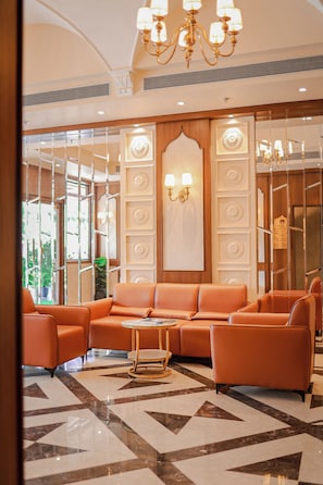 A lobby with a seating area, a chandelier, and a patterned floor. - HOTEL MUMBAI HOUSE DIGHA AIROLI (Navi Mumbai)