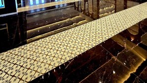 Een ruime lobby met een spiegelende vloer, een kamerbreed tapijt met dessin en een plafond met geometrisch ontwerp.