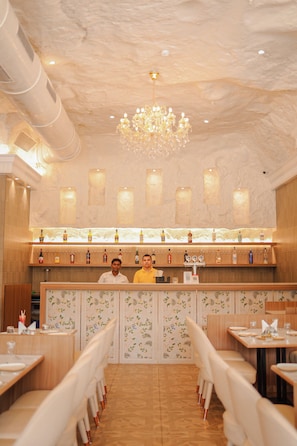 A restaurant with a bar area, wooden furniture, and a chandelier. - HOTEL MUMBAI HOUSE DIGHA AIROLI (Navi Mumbai)