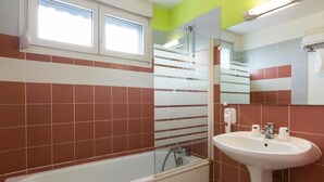 Un baño con bañera, lavamanos y espejo.