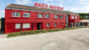 Un edificio rojo con el letrero "ENZO HOTELS" en el techo.