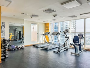 A modern gym with treadmills, weight machines, and free weights. - Chic 1BR APT in Business Bay Close To Burj Khalifa (Dubai)