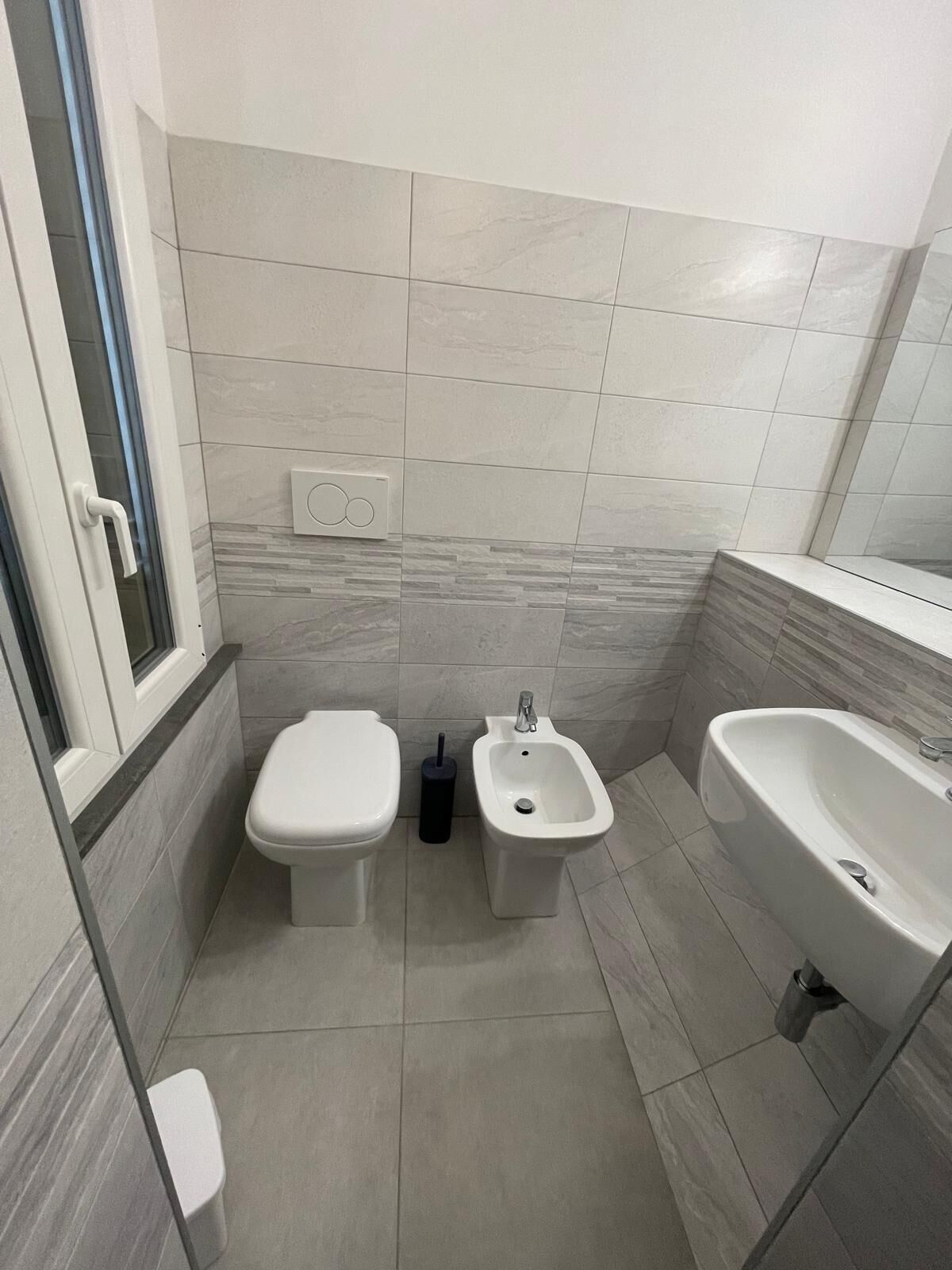Un bagno moderno con toilette, bidet e lavandino.
