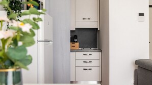 A compact kitchen with white cabinets, a built-in oven, and a small countertop. - Garibaldi - Modern 1 BR in Brera by Rentopolis (Milano)
