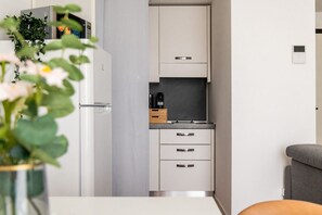 A compact kitchen with white cabinets, a built-in oven, and a small countertop. - Garibaldi - Modern 1 BR in Brera by Rentopolis (Milano)