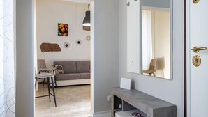 A modern interior with a sofa, chairs, a mirror, and a console table.