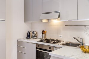 A modern kitchen with stainless steel appliances, a built-in oven, and a double sink. - Apartment 'Appartamento Speranza' with Wi-Fi and Air Conditioning (Grosseto)
