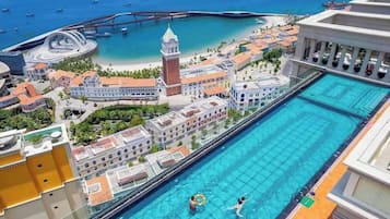 A hotel with a swimming pool, a beach, and a tower.