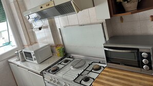 Ett kök med spis, mikrovågsugn och ugn.
