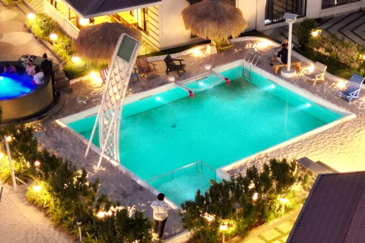 Ein Außenpool mit Rutsche, umgeben von Liegestühlen und einem kleinen Whirlpool.