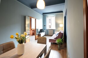 Ein modernes Wohnzimmer mit Essbereich, einer Couch und einem Fernseher.