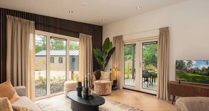 Stay in a luxurious holiday home for 4 people in the heart of the forested Veluwe, featuring modern amenities, air conditioning, a stylish pergola, and where pets are welcome.