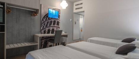 A hotel room with two beds, a desk, a chair, a television, and a wardrobe.