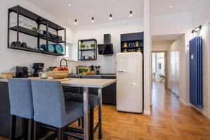 A modern kitchen with a central island, built-in shelves, and a refrigerator. - LVD Lucina Luxury Apartament al Centro di Roma (Rome)