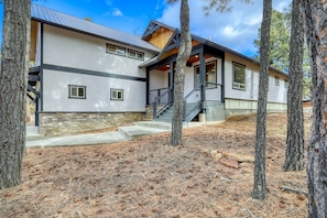 A modern two-story house with a stone foundation, a metal roof, and a wooden deck. - Pagosa Springs mountain-modern 4BR house with hot tub, deck, fireplace, and forest views; sleeps 8. (Pagosa Springs)