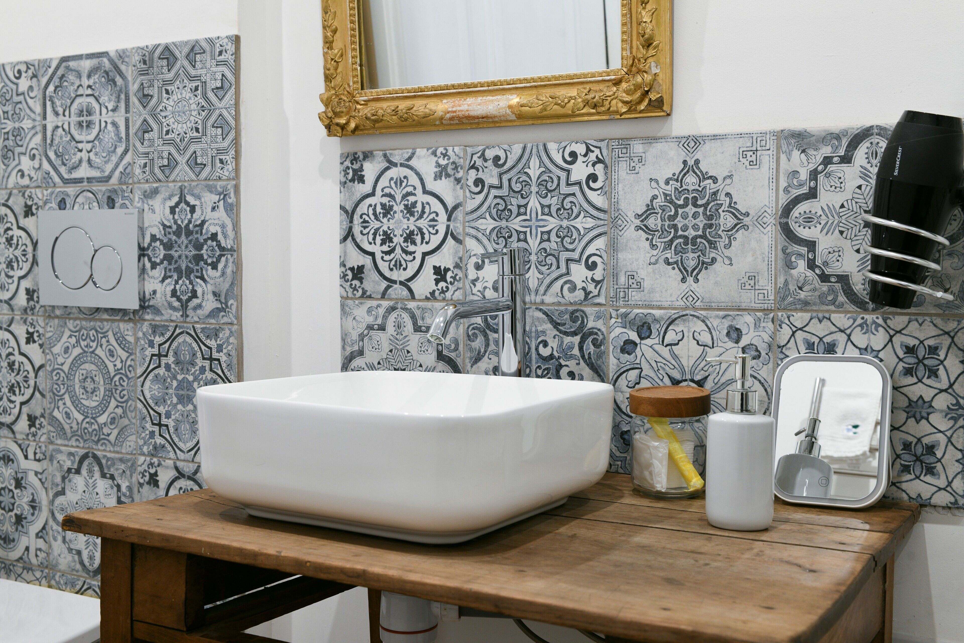 A bathroom with a white sink, a mirror, and a towel rack.