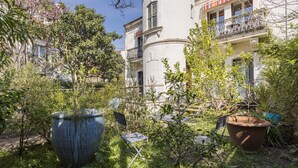 Un cortile con un vaso grande, una sedia pieghevole e un edificio con balconi.