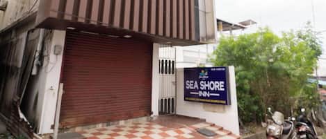 A building with a vertical striped facade and a closed red shutter door.