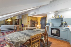 Een gezellige keuken met een eettafel, stoelen, een magnetron en een oven.