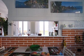 Eine Küche mit Backstein-Spritzschutz, einem Fenster mit Blick auf eine Stadtlandschaft und einer Essecke mit Tisch für zwei Personen.