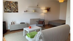 A modern living room with a sofa, a coffee table, a TV, a lamp, and a painting on the wall. - Cantinho da Luísa (Coimbrã- Atouguia da Baleia)