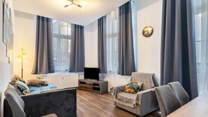 Una sala de estar moderna con un sofá, un sillón y un mueble para la televisión.