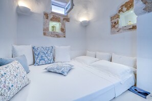 Ein Zimmer mit einem Bett, Kissen, einem Buch und einem Fenster mit Blick.