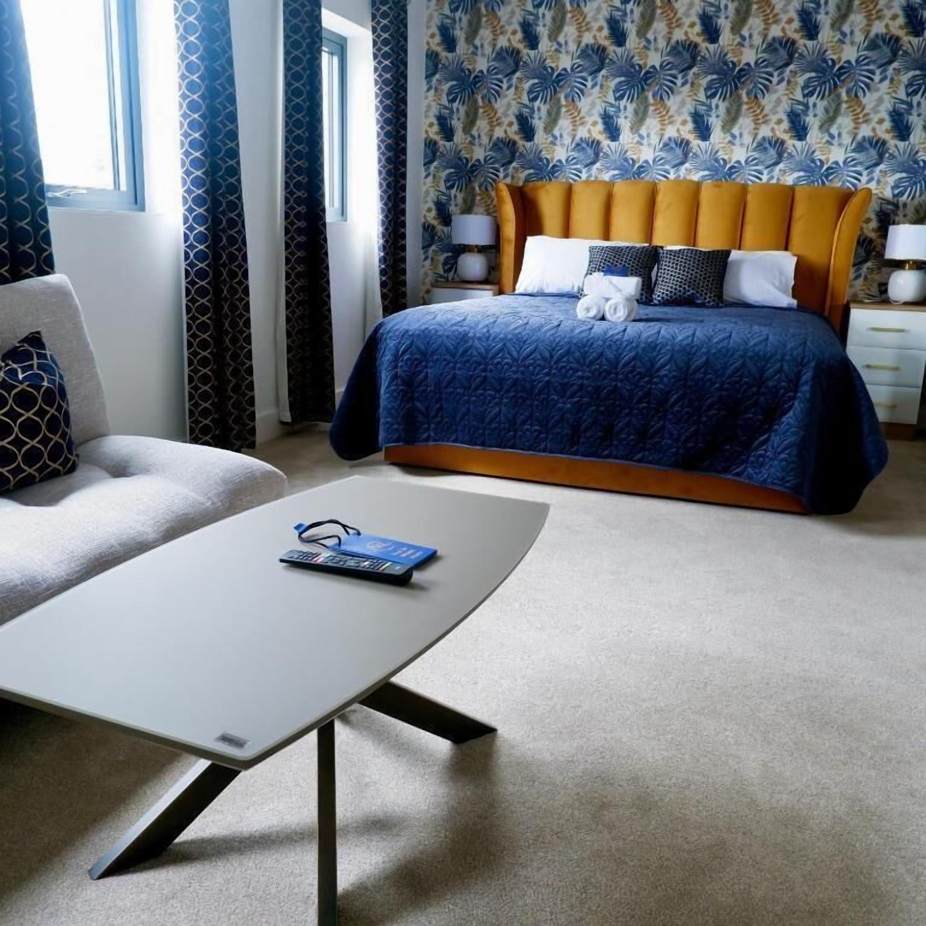 Une chambre d’hôtel avec un lit, une chaise, une table et une fenêtre.