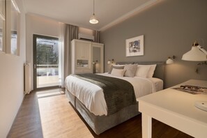 Een slaapkamer met een bed, nachtlampen, een nachtkastje, een raam met gordijnen en een aan de muur hangend schilderij.