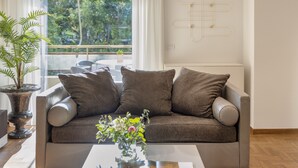 A modern living room with a sofa, a coffee table, and a potted plant. - Nikita 1 3rd·Signature Athenian Residence (Athens)