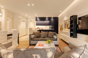 A modern living room with a sofa, coffee table, and a flat-screen TV. - Nikita 1 3rd·Signature Athenian Residence (Athens)