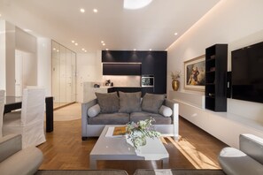 A modern living room with a sofa, coffee table, and a flat-screen TV. - Nikita 1 3rd·Signature Athenian Residence (Athens)