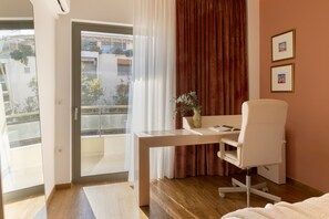 Hotelkamer met bureau, stoel en uitzicht.