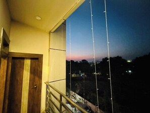 A balcony with a view of a sunset over a hilly landscape. - Hotel New M.I. Plaza (Gaya)