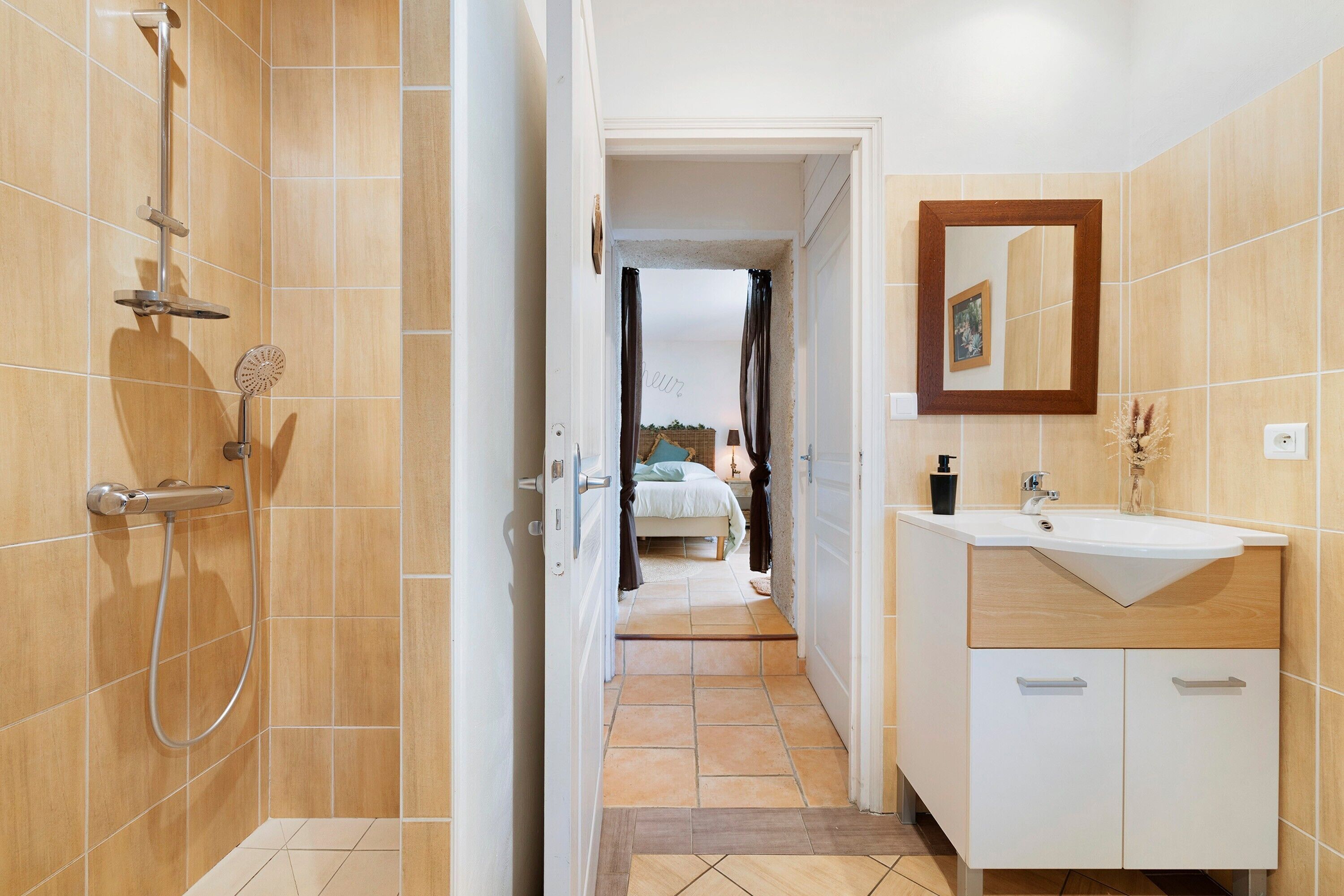 Ein Badezimmer mit Dusche, Waschbecken und Spiegel.