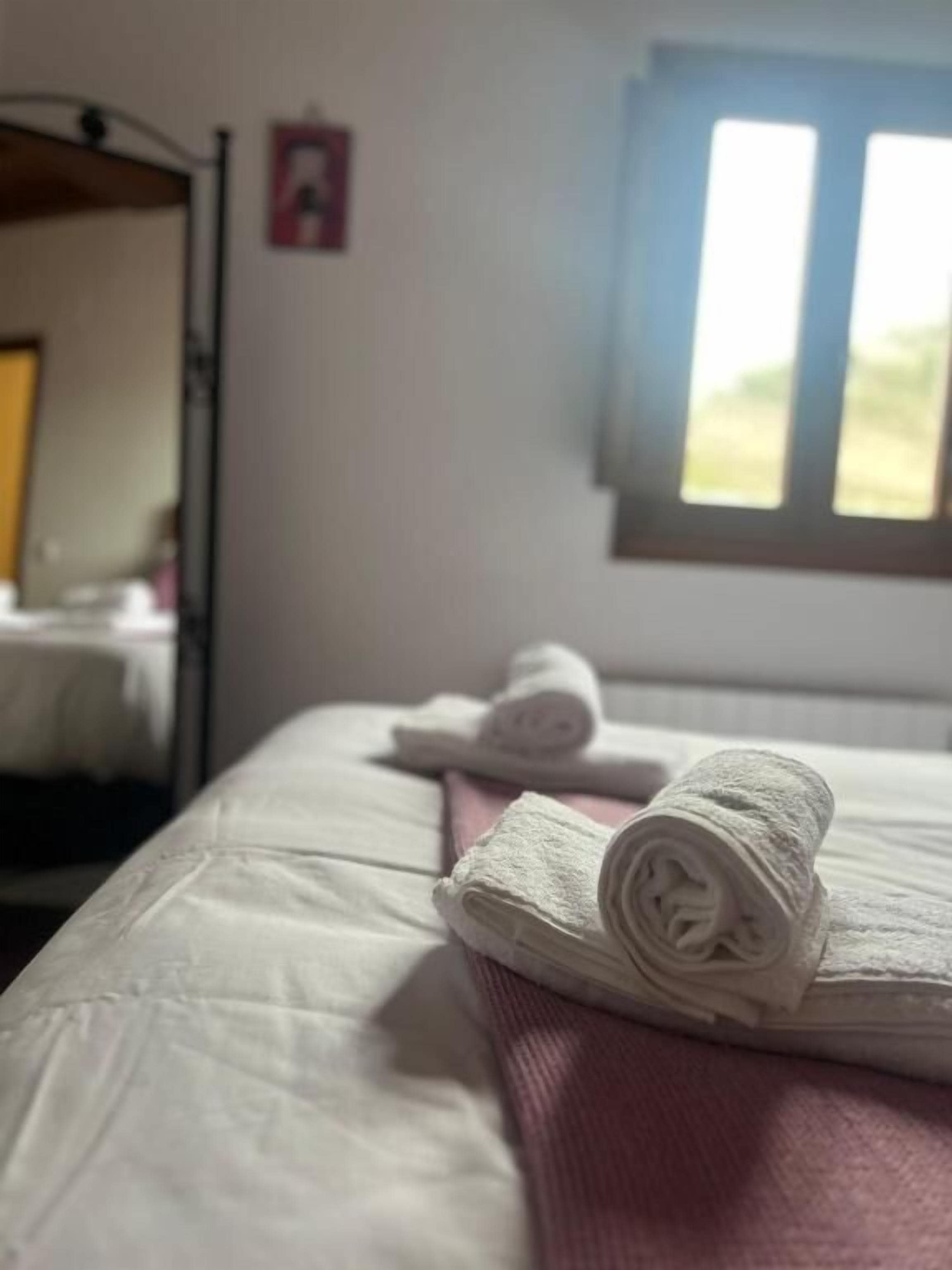 Un dormitorio con cama, ventana y un cuadro en la pared.