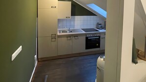 Una cocina moderna con tragaluz, horno empotrado y pileta.