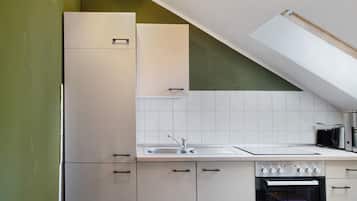 Una cocina con armarios blancos, un fregadero y un horno empotrado.