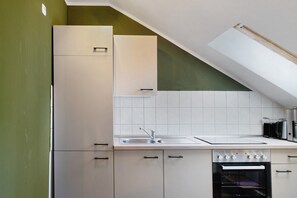 A kitchen with white cabinets, a sink, and a built-in oven. - Apartment 'Gutsherren Räume Im Gutshaus Groß' with Wi-Fi (Gülzow-Prüzen)