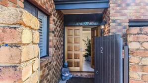 A brick building with a wooden door and a number '2' sign.