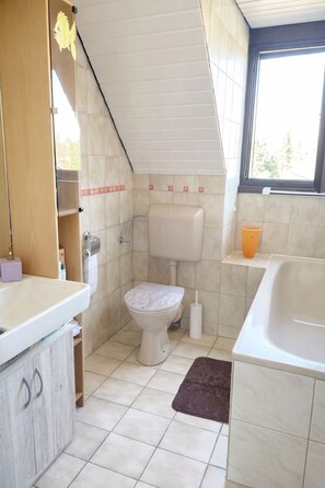 Ein kleines Badezimmer mit Toilette, Waschbecken und Badewanne.
