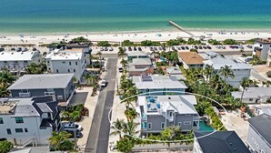 A coastal hotel with multiple buildings, a beach, and a pier. - Beach & Bay by Beach Boutique Rentals (Bradenton Beach)