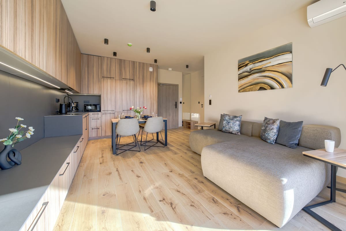 A modern apartment with a kitchen, dining area, and living room.