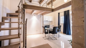 Un intérieur moderne comprenant un escalier, un coin repas et une cuisine.