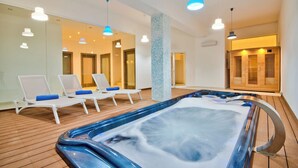 A spa room with a hot tub, lounge chairs, and a mirror wall. - Extraordinary Villa With Private Pool & Steamsauna (Mellieha)