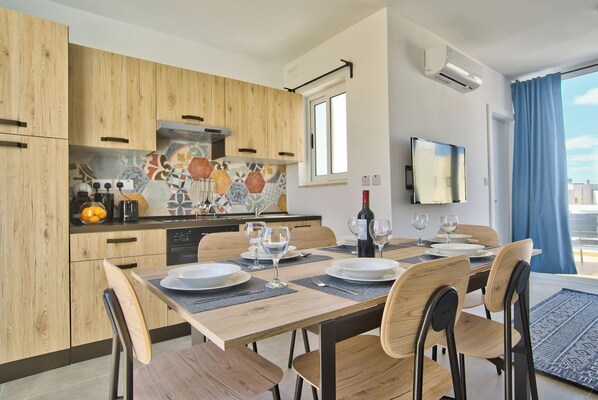 A modern kitchen with wooden cabinets, a tiled backsplash, and a dining area with a table set for four.
