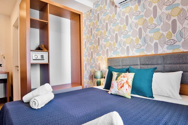 A hotel room with a bed, a wardrobe, a desk, and a patterned wallpaper. - Best Location Sliema Tower Road Apartment (Sliema)