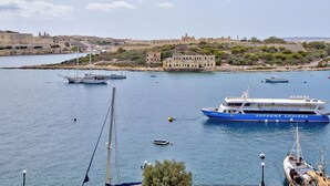 A harbor with several boats, including a large blue cruise ship named 'GOZO, COMINO & BLUE LAGOON'. - Central Sunny Apartment + Views of Valletta City (Sliema)