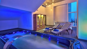 Un espace avec un bain à remous, des chaises longues et un sauna.